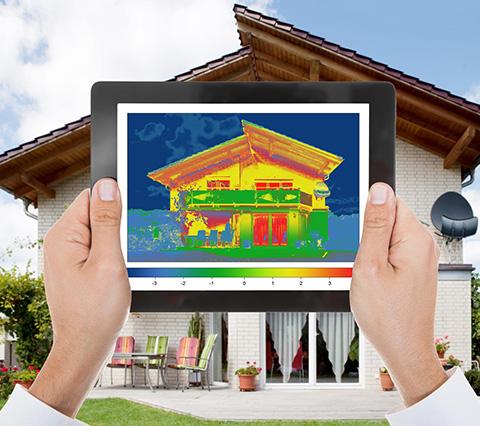 Image of Man Looking at Temperature Readings in Front of House